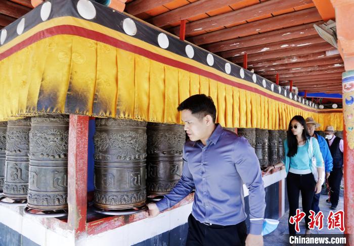 圖為外籍嘉賓體驗藏族傳統(tǒng)轉經(jīng)筒?！●R銘言 攝