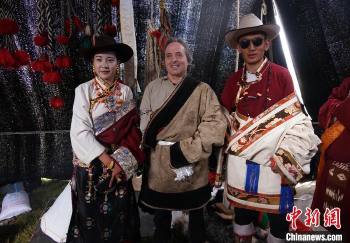 圖為一名外籍?dāng)z影師(中)身穿藏服和藏族民眾合影留念。　馬銘言 攝