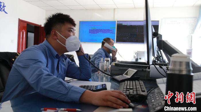 圖為貨運調(diào)度人員與外勤工作人員聯(lián)系掌握車輛裝載情況。　李生燕 攝