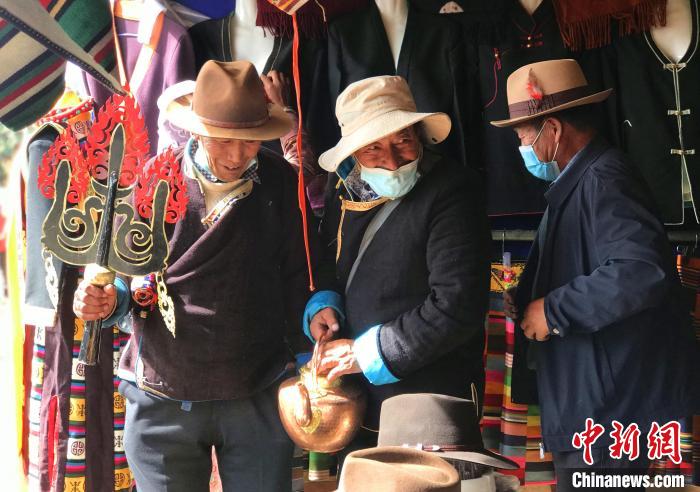圖為三位藏族老人在集市上聊天交談?！∪轿木?攝