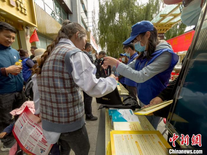 圖為志愿者為市民發(fā)放網(wǎng)絡(luò)安全宣傳手冊。　謝牧 攝