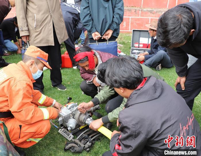 圖為森林消防員為護(hù)林員講解滅火裝備的使用方法。　昌都市森林消防支隊 供圖