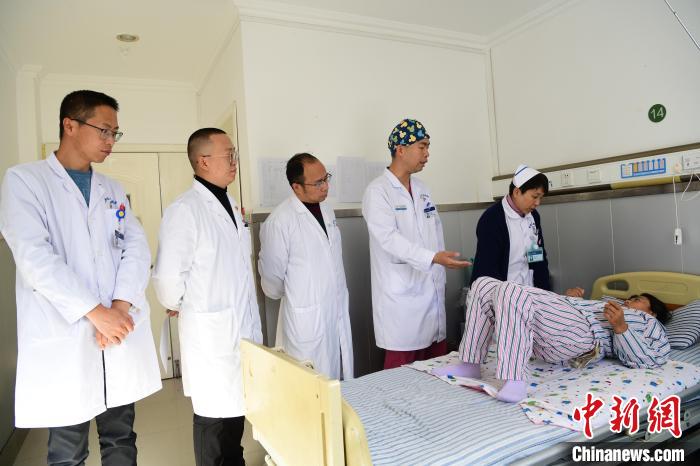 圖為何蔚副主任醫(yī)師(站右二)及團隊術后指導患者進行腰背肌鍛煉。　貢嘎來松 攝