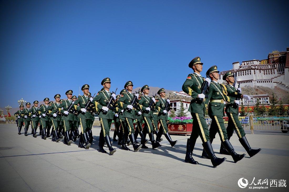 國旗護(hù)衛(wèi)隊(duì)隊(duì)員緊握鋼槍，踏著威武雄壯的步伐，走向國旗臺。人民網(wǎng) 次仁羅布攝
