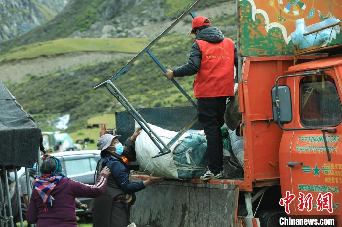 圖為工作人員幫助牧民們卸家具?！÷蹇?攝