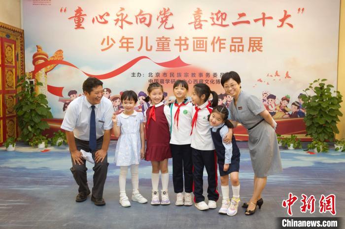 圖為與會嘉賓與入選畫作的“小作者”們在展覽上合影?！≈袊貙W(xué)研究中心供圖