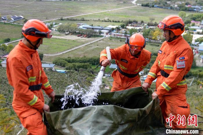 技能大練兵過程中，消防員在陡坡上向蓄水池注水?！±顕鵂c 攝