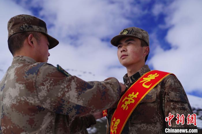 排長(zhǎng)王朝偉(圖左)給退伍老兵佩戴大紅花。　西藏山南軍分區(qū)某團(tuán)供圖