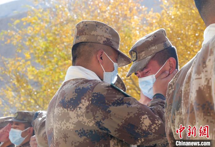 圖為什布奇邊防連退伍老兵與戰(zhàn)友相擁而泣，依依惜別。　徐昌成 攝