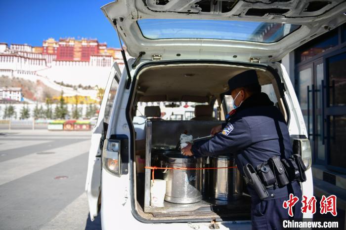 圖為1月23日，布達(dá)拉宮廣場(chǎng)派出所民警正在打午飯?！∝暩聛?lái)松 攝