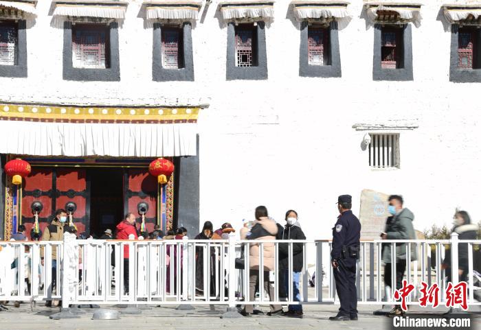 圖為1月23日，布達(dá)拉宮廣場(chǎng)派出所民警正在引導(dǎo)游客?！∝暩聛?lái)松 攝