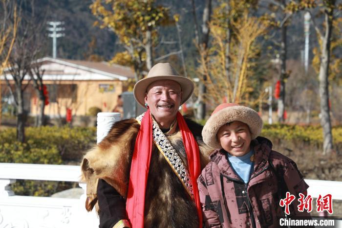 圖為林芝市巴宜區(qū)布久鄉(xiāng)仲果村村民桑杰與孫子一起參加藏歷新年活動?！埩?攝