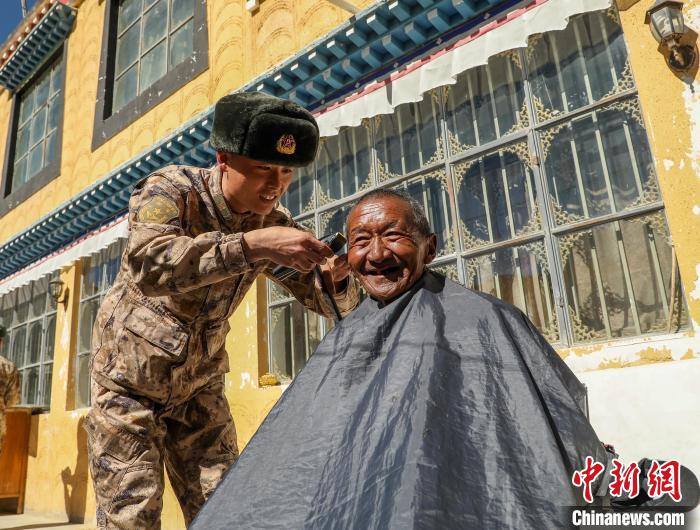 圖為阿里軍分區(qū)某邊防團官兵為駐地群眾理發(fā)迎藏歷新年?！〉┰鰝愔?攝