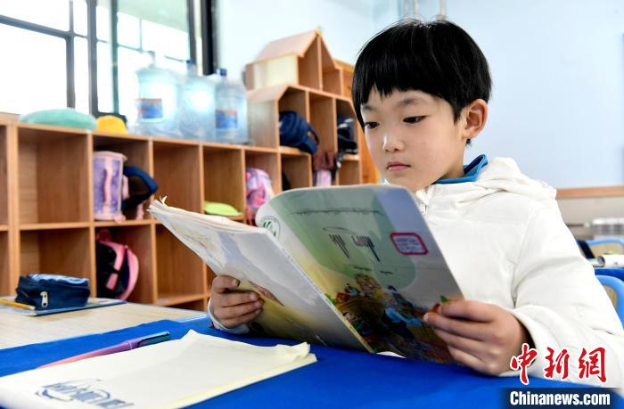 3月14日，西藏拉薩市第一小學一年級六班學生丁增樂吉在閱讀藏語課本。　李林 攝