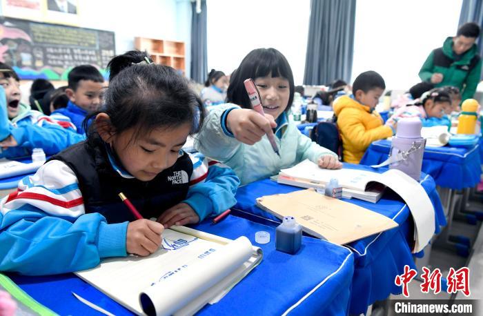 3月14日，西藏拉薩市第一小學一年級六班學生白瑪朗珍(圖左)在藏語文課上書寫藏文?！±盍?攝