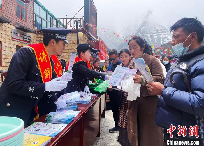 圖為山南玉麥邊境派出所民警為轄區(qū)群眾發(fā)放法律知識(shí)宣傳單?！＄婗?　攝