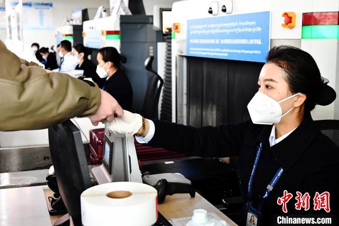 圖為機場工作人員為旅客辦理行李托運?！≈芎?攝