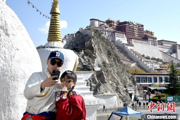 4月17日，游客身著藏式元素服裝在拉薩布達(dá)拉宮觀景臺(tái)拍照留念?！±盍?攝
