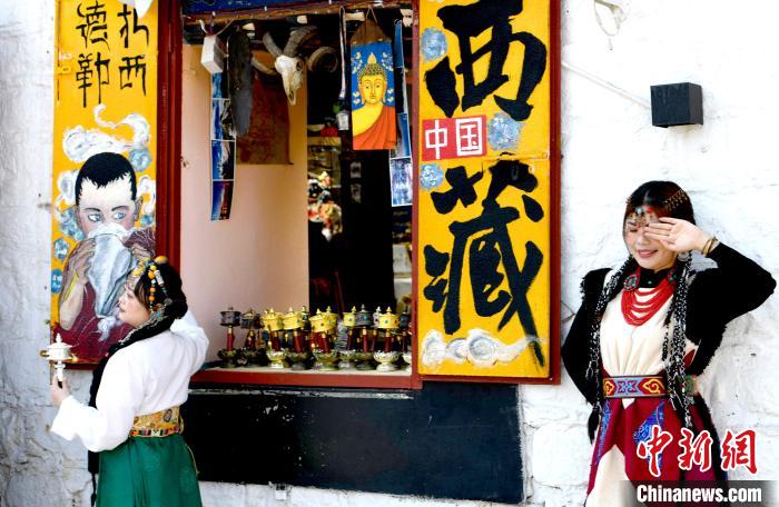 4月17日，游客身著藏式元素服裝在拉薩八廓街拍照留念?！±盍?攝