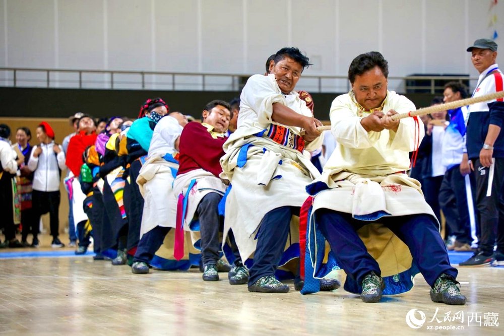 身著民族服裝的農(nóng)牧民選手在拔河比賽現(xiàn)場。