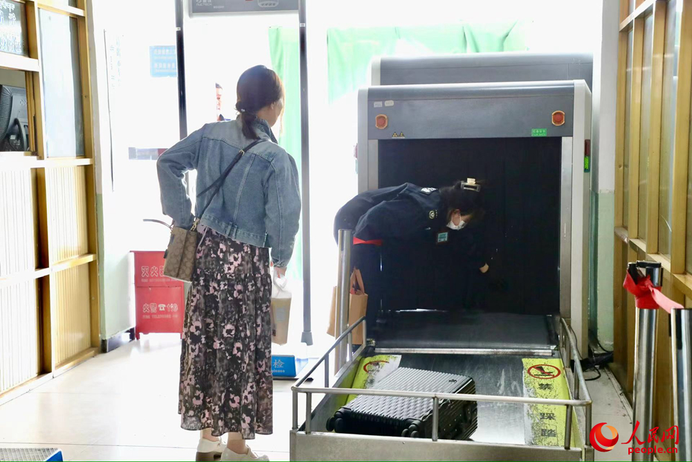 車(chē)站工作人員幫旅客提取行李。人民網(wǎng)記者 次仁羅布攝