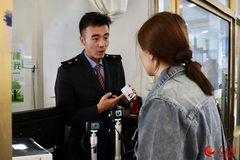 車(chē)站工作人員向旅客解答疑問(wèn)。人民網(wǎng)記者 次仁羅布攝